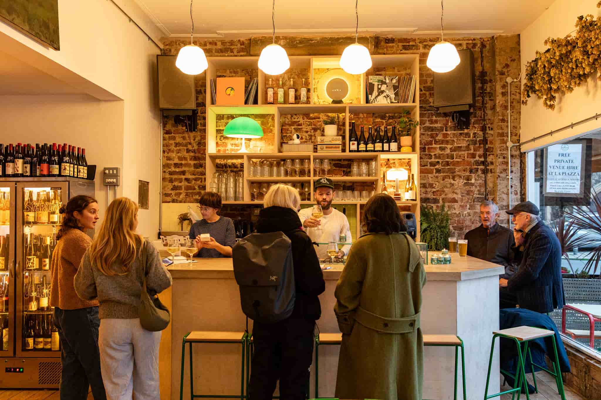 People stood buying drinks at bar by Ellen Richardson